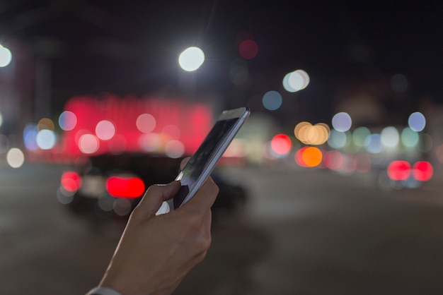 Telefone na mão de uma mulher à noite