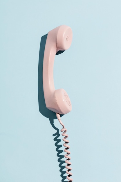 Telefone pastel rosa sobre fundo azul claro Telecomunicações