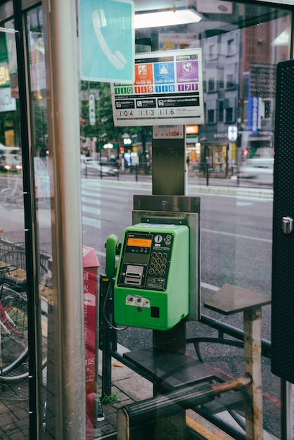 Telefone público na cidade atrás de painel de vidro