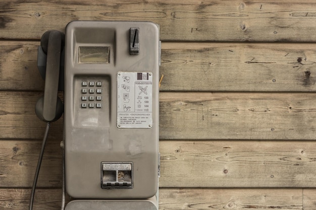Telefone público na parede de madeira de uma casa