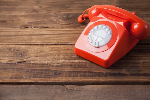 Foto telefone vermelho na mesa de madeira