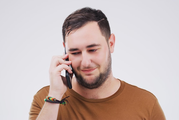 Telefonema de bate-papo e homem ouvindo no estúdio isolado em um fundo branco Chamando celular e pessoa do sexo masculino conversando ou conversando e fazendo networking com contato no celular