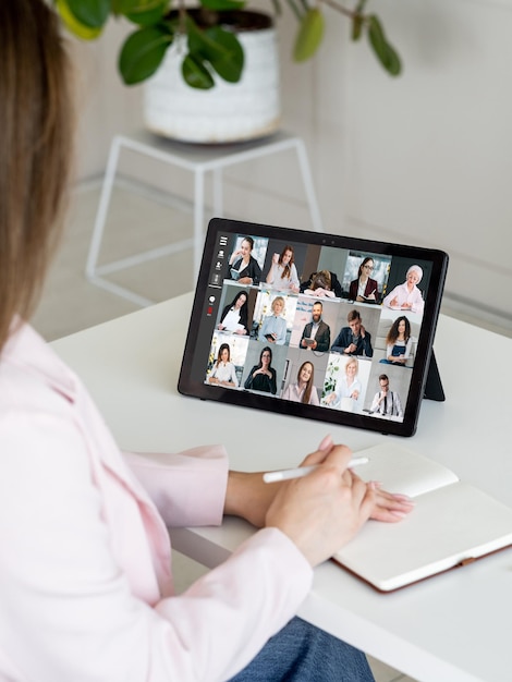 Telefonkonferenz des Geschäftsteams Remote-Meeting Virtuelle Zusammenarbeit Mitarbeiterin nutzt Tablet, um online mit Kollegen auf dem Bildschirm im digitalen Büro zu arbeiten