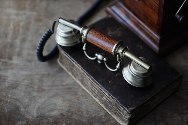 Foto teléfono antiguo y libro retro sobre una mesa de madera