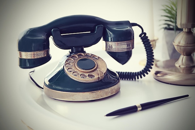 Teléfono antiguo en una mesa blanca.