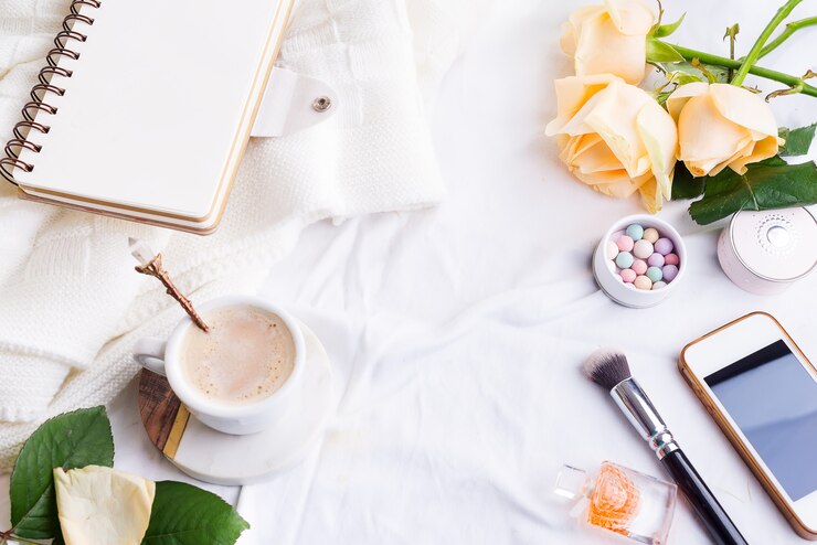 Foto teléfono, blanco taza de café y rosas con cuaderno en cama blanca y cuadros, acogedora luz de la mañana.