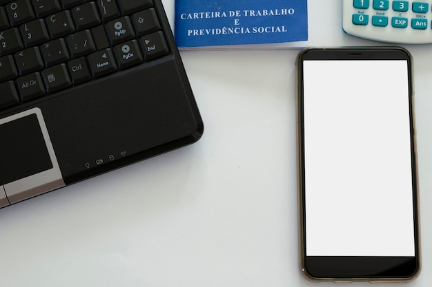 Teléfono celular de pantalla blanca, computadora, calculadora y tarjeta de trabajo brasileña. concepto de trabajo en casa
