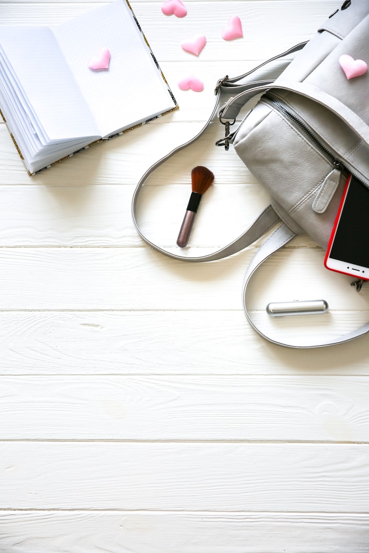 Foto teléfono, elegante bolso y perfumes sobre fondo blanco. hermosa endecha plana. cosas para mujer de negocios. horario del cuaderno. kit de maquillaje. regalo de niña con corazones.