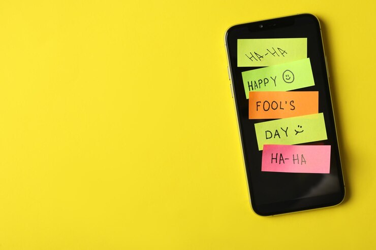 Foto teléfono inteligente cubierto con pegatinas y espacio para texto sobre fondo amarillo vista superior día de los inocentes