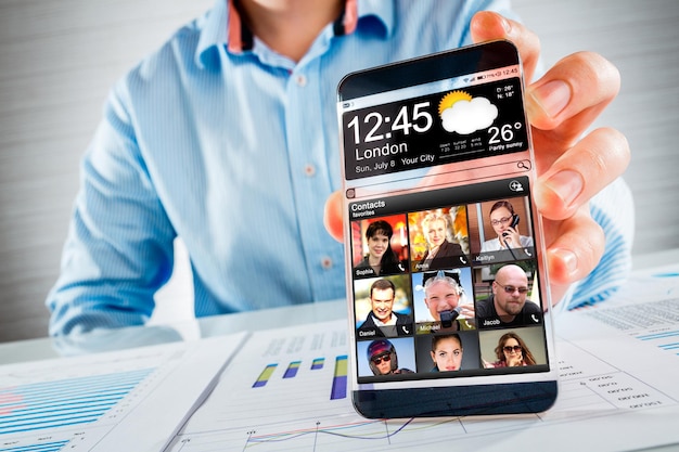 Teléfono inteligente futurista (phablet) con una pantalla transparente en manos humanas. Concepto de ideas innovadoras futuras reales y las mejores tecnologías de la humanidad.