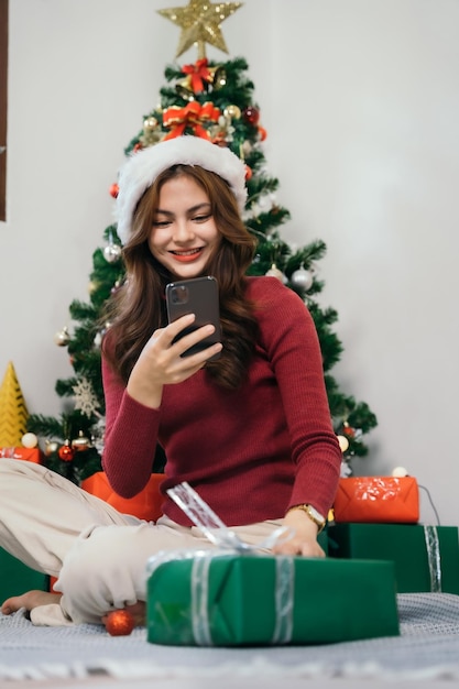 Teléfono inteligente de mano de mujer en el fondo de navidad