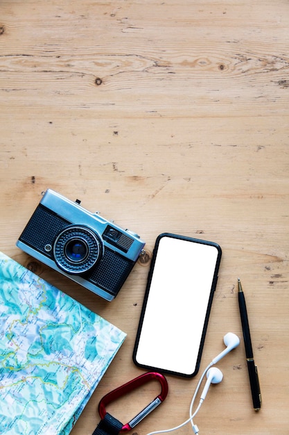 Foto teléfono inteligente moderno con artículos de viaje pantalla de teléfono en blanco