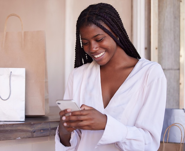 Teléfono inteligente de mujer negra y compras felices y comunicación minorista y venta con descuento de ganga con tecnología Bolsa de compras de teléfono en centro comercial y mensaje de texto de redes sociales y aplicación móvil