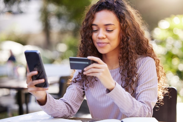 Teléfono inteligente de mujer y tarjeta de crédito en un restaurante al aire libre con verificación de finanzas Persona femenina que paga y móvil para un pago en línea en un café en la naturaleza en una aplicación con tecnología