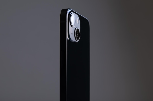 Teléfono inteligente negro rectangular moderno con bordes rectos y dos cámaras grandes en un gris aislado