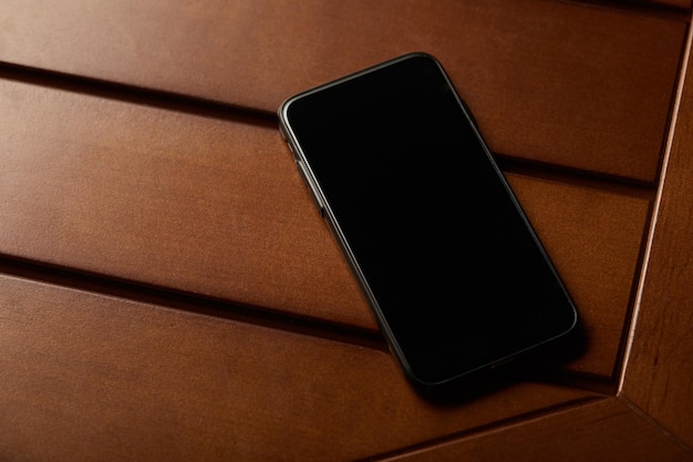Teléfono inteligente con pantalla en blanco y espacio de copia en mesa de madera