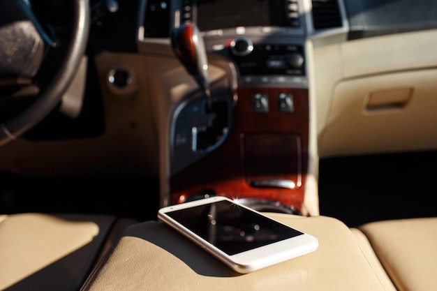 Teléfono inteligente en el salpicadero del asiento del coche