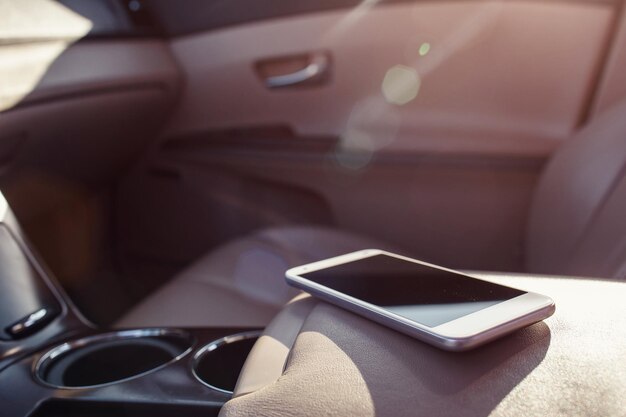 Teléfono inteligente en el salpicadero del asiento del coche