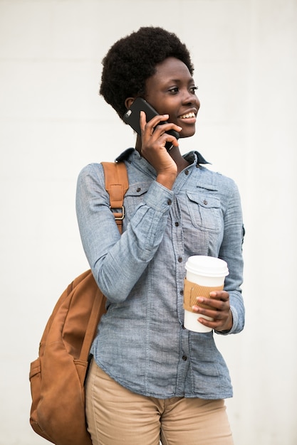 Teléfono joven mujer negra caminando