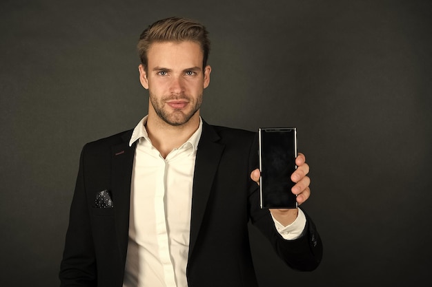 El teléfono lo mantiene organizado Hombre de negocios mostrar teléfono móvil Hombre guapo con teléfono celular Teléfono para uso personal y profesional Estilo de vida móvil 3G y 4G Teléfono inteligente para mantenerse en contacto