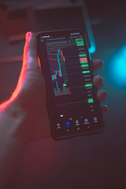 Teléfono de mano con gráfico de la bolsa de valores