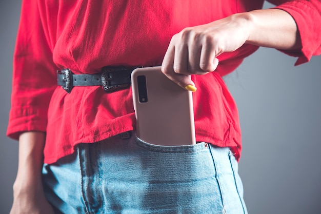 Teléfono de mano de mujer en el bolsillo