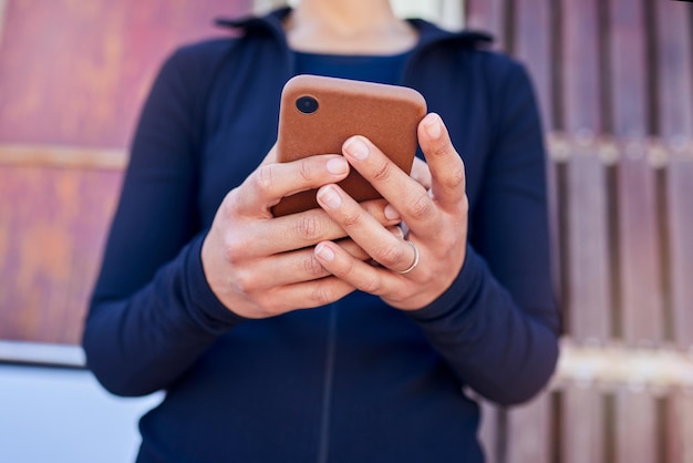 Teléfono de manos y mujer al aire libre para búsqueda de ubicación o mapa de Internet o guía de viaje con texto en la calle de la ciudad Aplicación para teléfono inteligente y dama en línea para notificación de redes sociales o chat web mientras espera