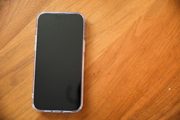 Un teléfono en una mesa de madera con la parte de atrás