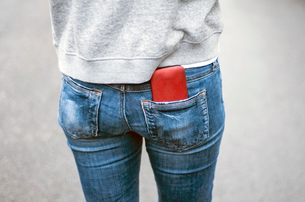 Teléfono móvil en el bolsillo de los pantalones vaqueros