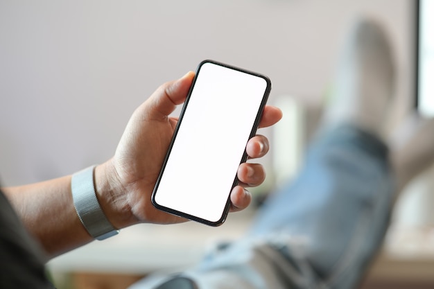 Teléfono móvil de mano masculina y pantalla en blanco.