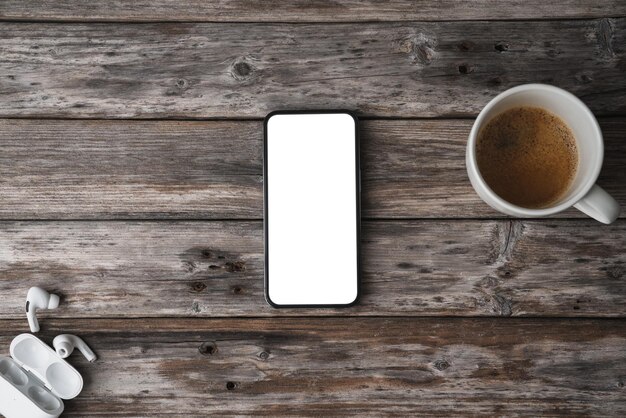 Teléfono móvil en una mesa de madera que muestra una captura de pantalla en blanco desde arriba