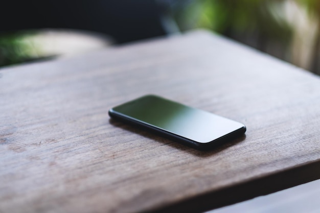 Un teléfono móvil en la mesa de madera.