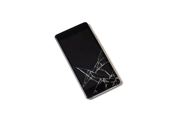 Un teléfono móvil o smartphone dañado con una pantalla rota en un primer plano de fondo blanco aislado
