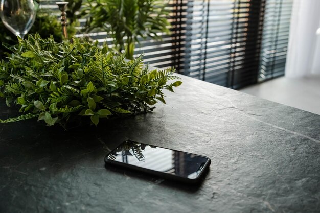 Teléfono móvil sobre una mesa teléfono celular negro sobre la mesa