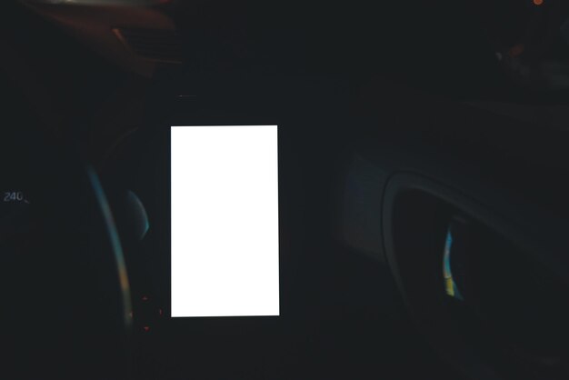 Foto teléfono móvil en la ventilación del coche blank con pantalla blancamock up teléfono inteligente en el coche texting espacio de copia para su anuncio