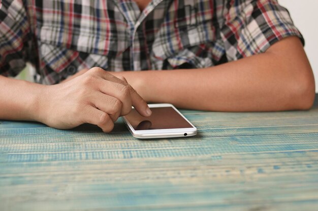 teléfono de prensa de mano en el concepto de mesa de madera como tecnología e internet