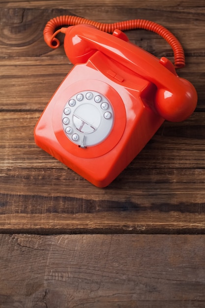 Teléfono rojo en la mesa de madera