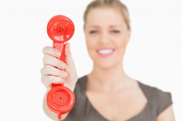 Teléfono rojo retro en una mano de mujer