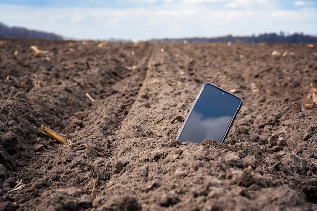 El teléfono sobresale del suelo en el campo.