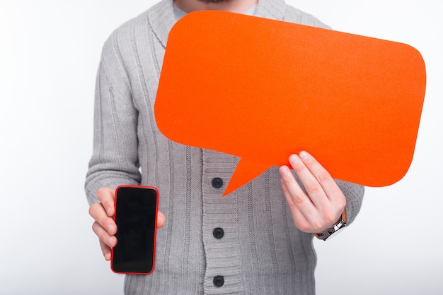 Foto ¡el teléfono tiene algo que decirte! hombre que sostiene un teléfono inteligente y un discurso de burbuja naranja por él.