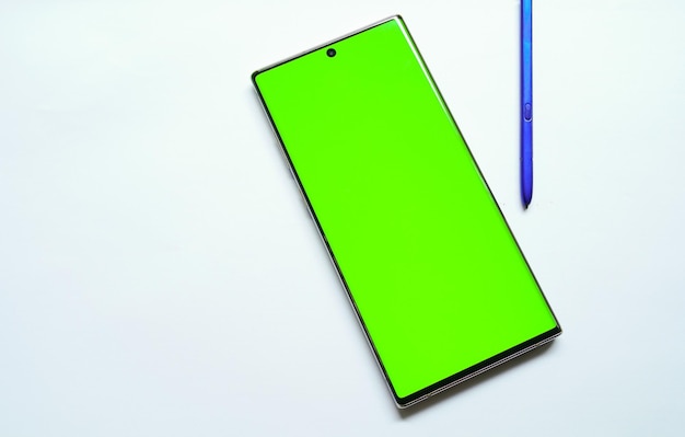 Un teléfono verde con un bolígrafo a un lado.