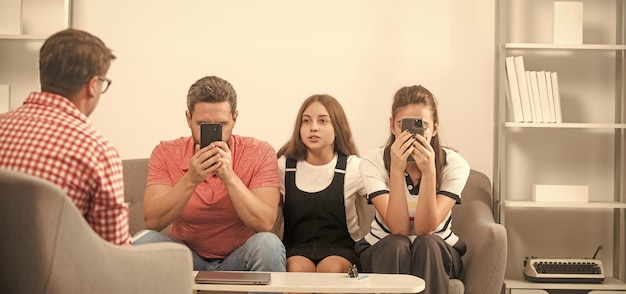 Telefonsüchtiger Vater, Mutter und Kind bei der Kommunikation mit dem Familienpsychologen