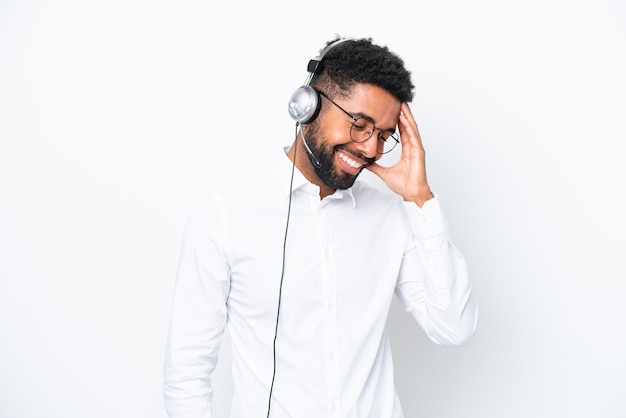 Telemarketer hombre brasileño que trabaja con un auricular aislado sobre fondo blanco riendo