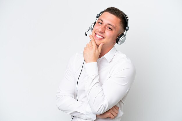 Telemarketer hombre brasileño que trabaja con un auricular aislado sobre fondo blanco sonriendo