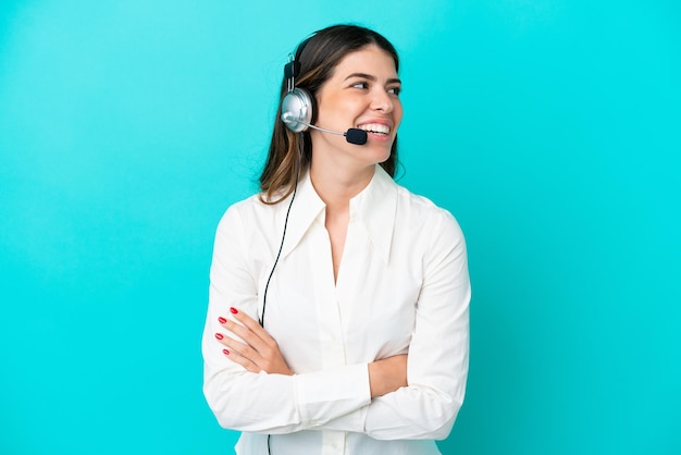 Telemarketer-Italienerin, die mit einem Headset arbeitet, isoliert auf blauem Hintergrund, glücklich und lächelnd