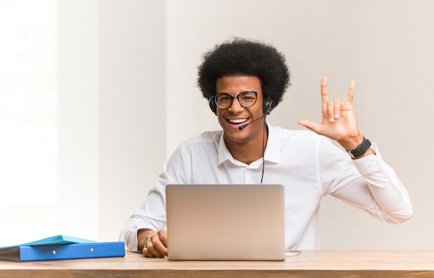 Telemarketer joven hombre negro haciendo un gesto de rock