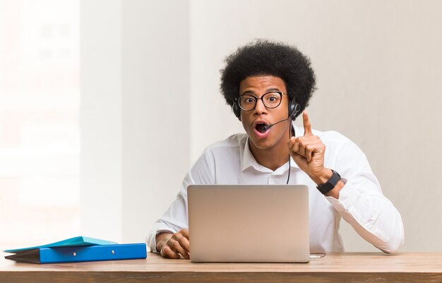 Telemarketer joven hombre negro teniendo una idea, inspiración