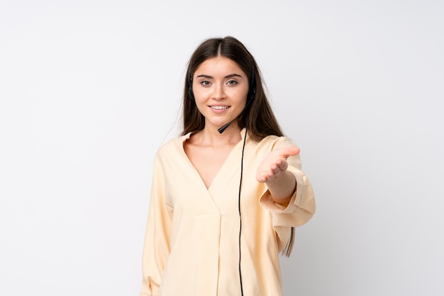 Foto telemarketer joven mujer sobre fondo blanco aislado apretón de manos después de un buen trato