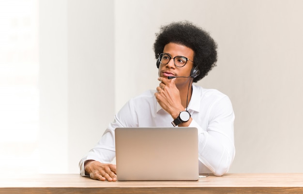 Telemarketer joven negro dudando y confundido