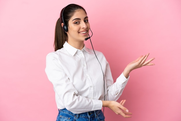 Telemarketer joven sobre antecedentes aislados extendiendo las manos hacia el lado para invitar a venir